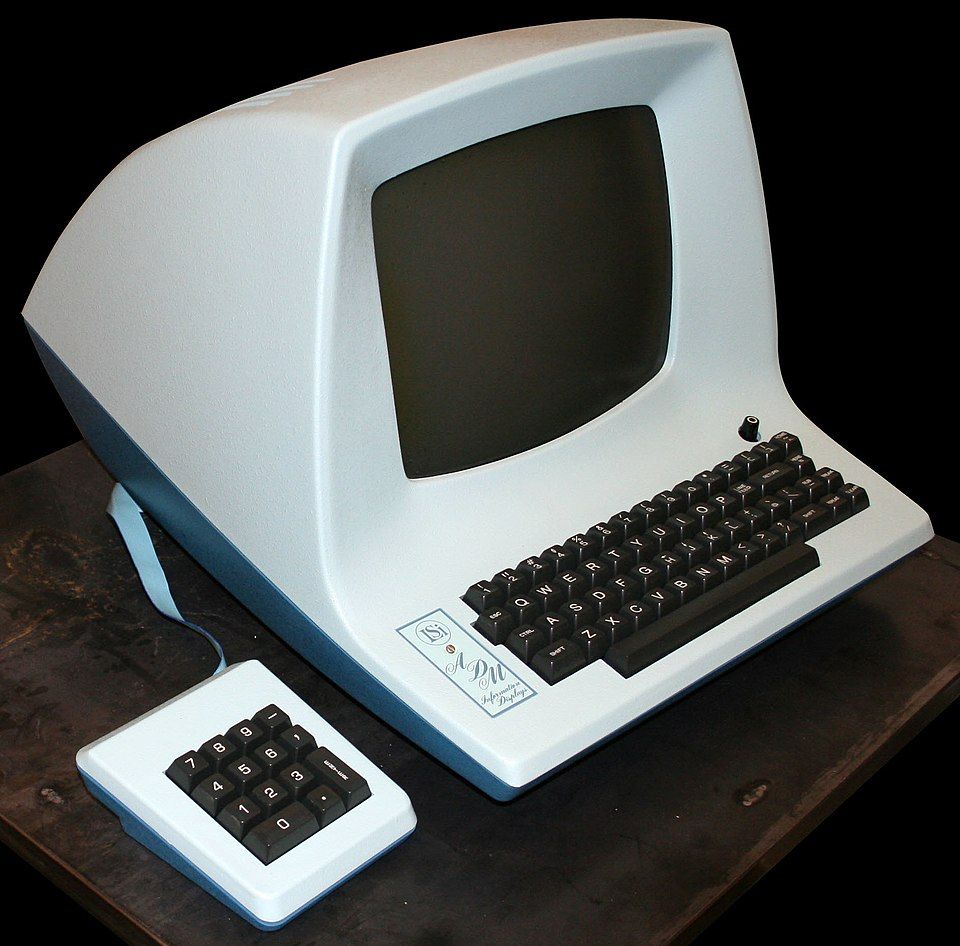 An ADM-3A terminal sitting on a desk. The keyboard and computer are a single piece of unibody hardware
